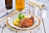 Fototapeta Mapy - Rabbit leg baked with beer and garlic with a drink of beer in the background