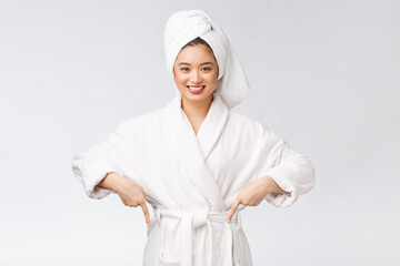 Beauty portrait of young woman showing and pointing finger to empty copy space, asian beauty in bathrobe.