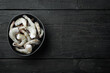 Frozen raw uncooked tiger prawns, shrimps, on black wooden background, top view flat lay, with copy space for text