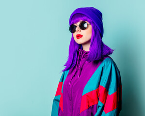 Canvas Print - Stylish white girl with purple hair, 80s tracksuit and sunglasses on blue background