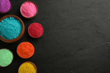 Colorful powder dyes on black background, flat lay with space for text. Holi festival