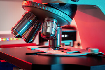 Poster - Toned photo of a backlit microscope lens in a science laboratory