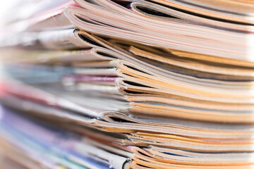 Stack of older slightly worn books colored magazines with narrow depth of field