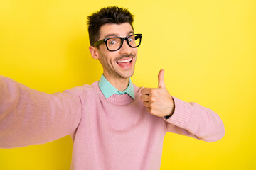 Sticker - Photo of young handsome attractive happy positive smiling man take selfie showing thumb-up isolated on yellow color background