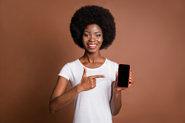 Sticker - Photo portrait of woman pointing finger on copyspace cellphone touchscreen promoting isolated on brown color background