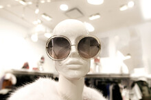 Closeup Of A Female Mannequin Wearing A Pair Of Oversized Round Sunglasses And A Fur Coat.