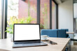 © Thinapob - Mockup of laptop computer with empty screen with coffee cup and smartphone on table of the coffee shop background,White screen