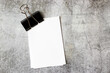 © Алена Ягупа - A stack of white sheets under a paper clip on a concrete surface