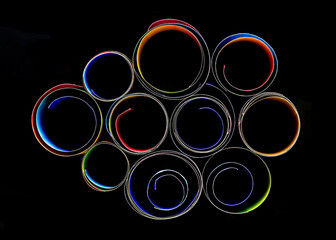 Wall Mural - Rolled colorful paper strips isolated on black background