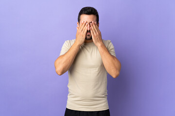 Poster - Young handsome man with beard over isolated background covering eyes by hands