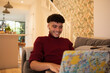 © Sam Edwards/Caia Image - Happy young man using laptop on sofa