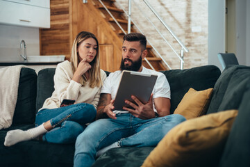 Couple using a digital tablet at home