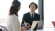 © taka - オフィスで打ち合わせをする男女