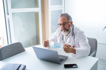 Wall Mural - Doctor has a video conference with a patient who shows a surgical mask to avoid contagion by Covid-19