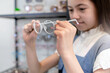 © chomplearn_2001 - Mixed-race child girl choosing glasses in optical shop, selective focus