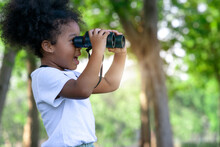 Little Dark Skinned Girl With Binoculars In Outdoor, Dark-skinned Girl Was Excited By The Image That She Saw Through Binoculars