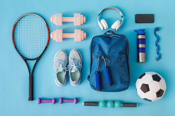 Set of sport equipment with backpack on color background