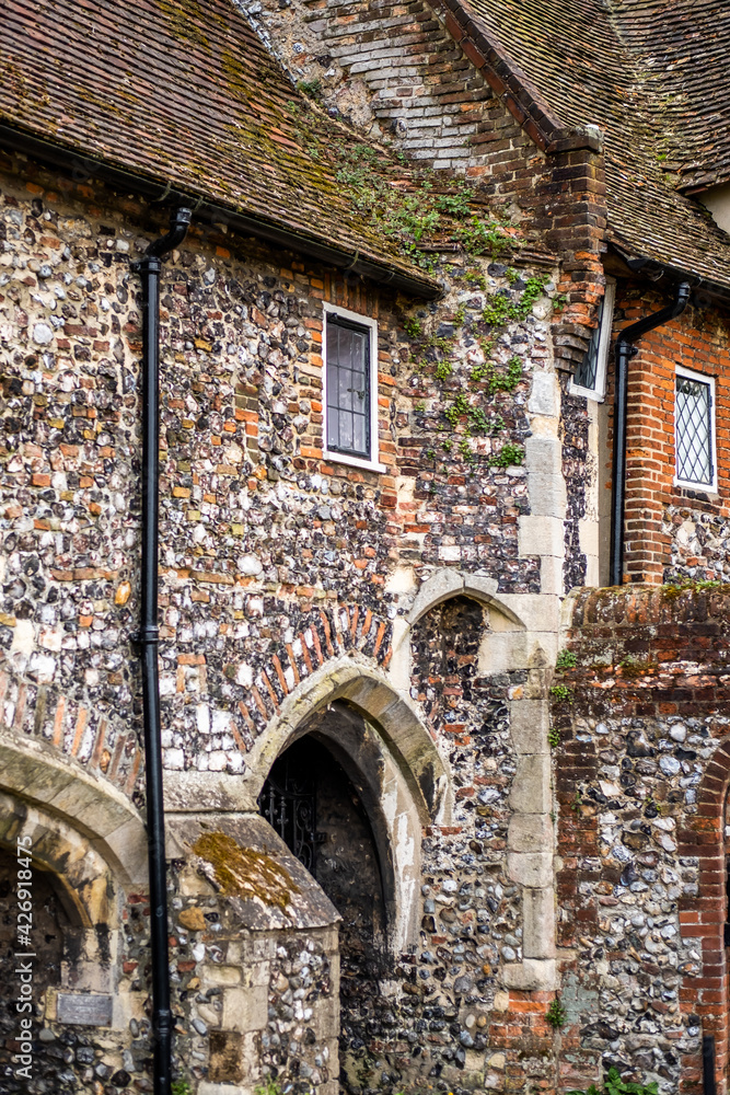 The exterior of an ancient flint built building on the bank of the ...