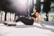 © shevtsovy - Fitness woman doing stretching legs exercise outdoors. Slim Fitness model posing. Female runner in sportswear exercising morning routine. Slim athletic woman run workout.