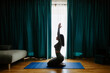 © shevtsovy - Young woman practicing yoga at home. meditation practice. Relaxation and meditation in living room. Beautiful fitness female wearing yoga pants gymnastics morning routine.