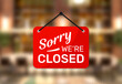 © Icons-Studio - Hanging sign for shop with text Sorry we're closed on blurred restaurant background.
