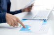 © NT_studio - Hand of young business man pointing document data graph and chart paper, marketing and investment, report of statistics profit for financial, economic and growth of finance, management and planning.