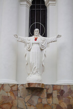 White Statue With Open Arms And Red Heart