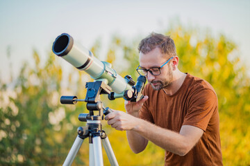 Wall Mural - amateur astronomer looking at the sky with a telescope.