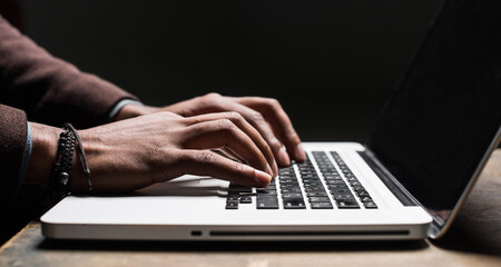 Businessman or man student using laptop at home, Male hands typing on computer keyboard closeup, online learning, internet marketing, working from home, office workplace, freelance concept