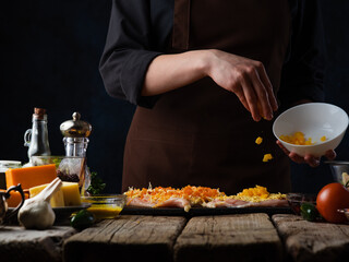 Wall Mural - Chef prepares rolls with chicken with dried apricots and cheese.On a dark background.Horizontal photo.Culinary recipes and cooking