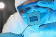 © H_Ko - Scientist developer in protective suit holds microcircuit