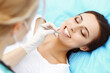 © rogerphoto - Young female patient visiting dentist office.Beautiful woman with healthy straight white teeth sitting at dental chair with open mouth during oral checkup while doctor working at teeth