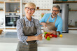 © NDABCREATIVITY - Happy senior couple cooking together and having fun in home kitchen