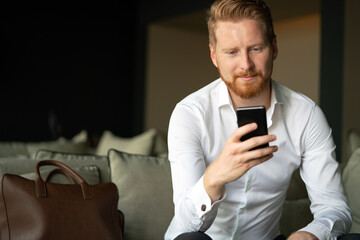 Poster - Young businessman sending message with mobile phone