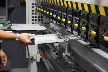 Wall Mural - The technician operator working with hydraulic press brake bending machine. The sheet metal working operation by skill operator.