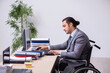 © Elnur - Young male enployee in wheel-chair at workplace