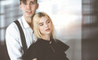 © rogerphoto - Young couple of businessman and woman are standing in a modern office. Portrait of successful business people