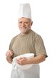© nyul - Senior chef whisking egg in kitchen, white background.