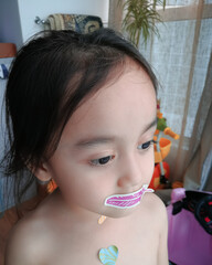 Little girl with glitter stickers on her face