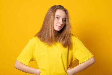 Wall Mural - Cute teen girl. Studio image of a cute smiling young girl on yellow background.