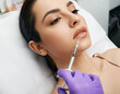 © Peakstock - Lip augmentation procedure. Lips filler injection for beautiful woman's lip augmentation with beautician at cosmetology clinic