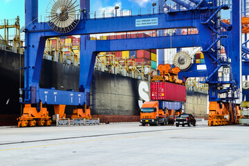 Wall Mural - Logistics and transportation of Container Cargo ship, quay crane load container onto truck. Container logistic import export and transport industry background.