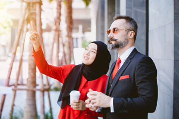 Wall Mural - Arab Muslim business people man and woman talking together planing future dream project together hand pointing at high