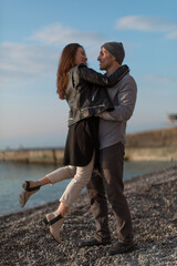 A couple in love guy and girl stand on the beach and cuddle. It's a beautiful love story. Beautiful seascape. High quality photo