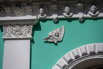 Wall Mural - white angels made of clay as a bas-relief decoration of an ancient building 