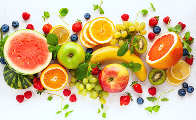 Wall Mural - Assorted fresh fruits and berries on white background. Clean eating, healthy life. Top view.