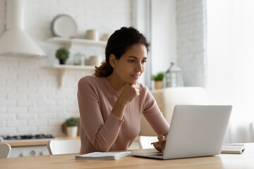 Poster - Web lecture. Focused young latina female sit at kitchen table look at pc screen listen to teacher think on problem to solve. Attentive lady remote student learn from home watch webinar training online