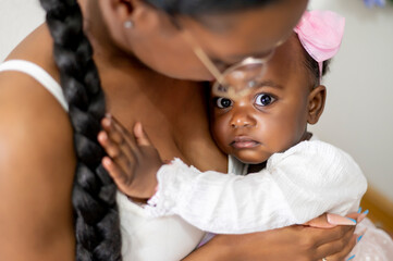 A baby girl with her mother in her arms