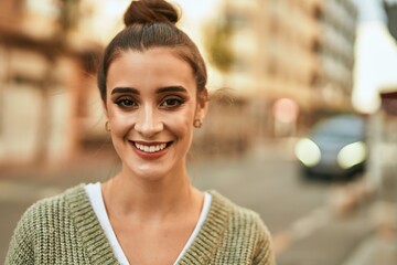 Wall Mural - Beautiful brunette woman smiling happy and confident outdoors at the city on a sunny day of autumn