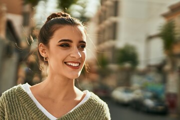 Beautiful brunette woman smiling happy and confident outdoors at the city on a sunny day of autumn